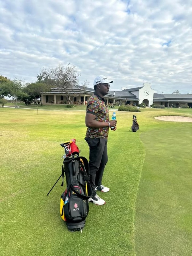 A golf bag on the tee, with the clubhouse beyond