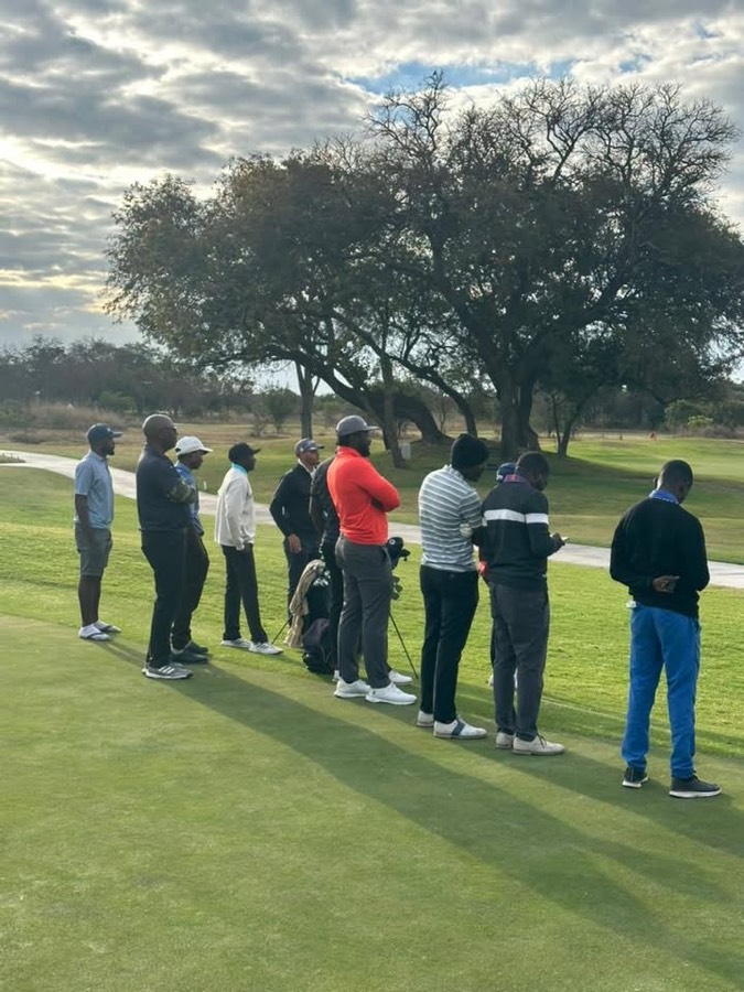 Players gathered on the green in the low evening light